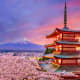 Red pagoda with Mount Fuji and cherry blossom trees at sunset in Japan